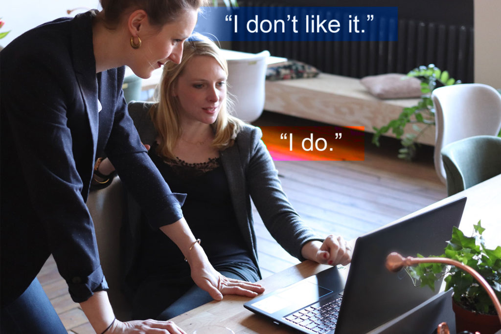 Two executives disagree while looking at a laptop monitor.